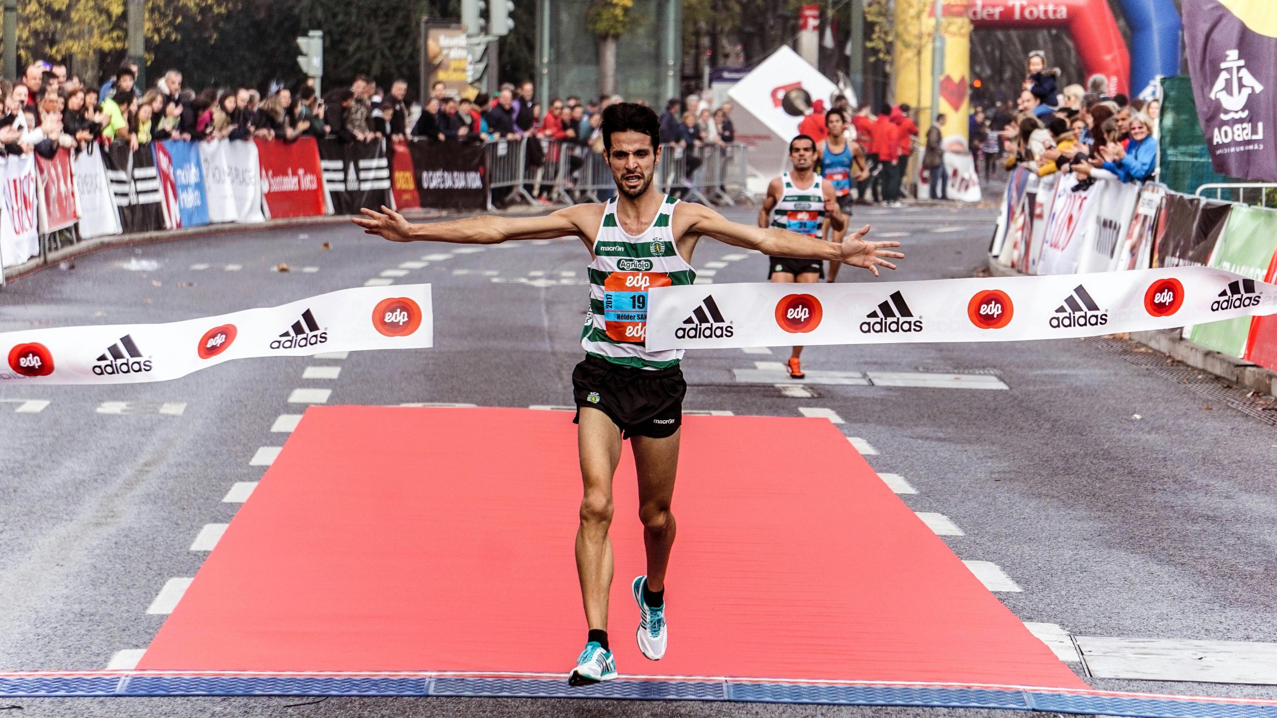 A triumphant marathon winner crosses the finish line, embodying athletic success.